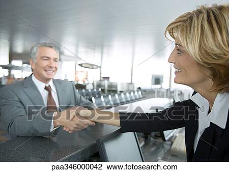 Airline attendant shaking hands with passenger View Large Photo Image Stock Image - Airline attendant shaking hands with passenger. Fotosearch