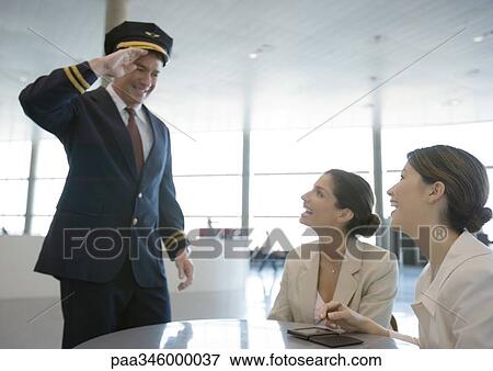 Airline pilot saluting two female travelers View Large Photo Image Stock Photo - Airline pilot saluting two female travelers. Fotosearch