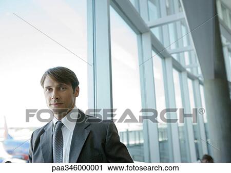 Businessman by window in airport View Large Photo Image Stock Image - Businessman by window in airport. Fotosearch