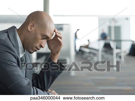 Businessman holding head in airport View Large Photo Image Picture - Businessman holding head in airport. Fotosearch