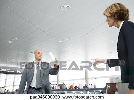 Businessman hurrying to departure gate, holding up ticket View Large Photo Image Stock Photo - Businessman hurrying to departure gate, holding up ticket. Fotosearch