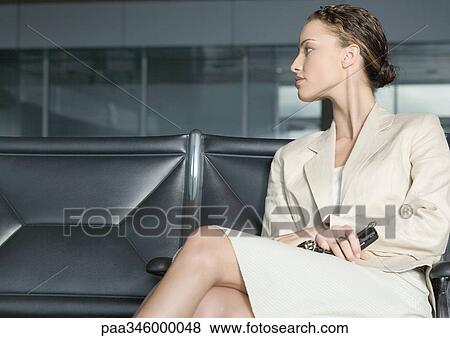 Female traveler sitting in airport lounge View Large Photo Image Stock Photo - Female traveler sitting in airport lounge. Fotosearch