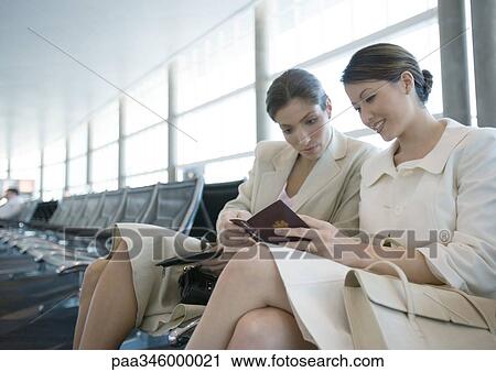 Two women sitting in airport lounge together View Large Photo Image Stock Image - Two women sitting in airport lounge together. Fotosearch