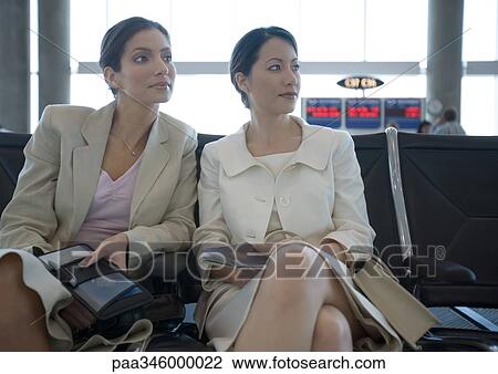Two women sitting in airport lounge together View Large Photo Image Stock Image - Two women sitting in airport lounge together. Fotosearch