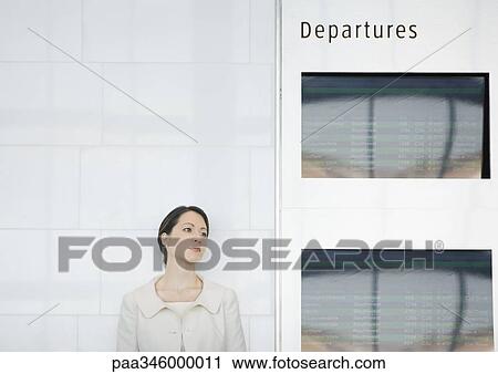 Woman leaning against wall by departure board View Large Photo Image Stock Image - Woman leaning against wall by departure board. Fotosearch