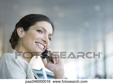 Woman using cell phone, smiling View Large Photo Image Stock Photograph - Woman using cell phone, smiling. Fotosearch