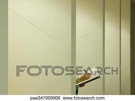 Person writing in agenda behind partition View Large Photo Image Stock Photograph - Person writing in agenda behind partition. Fotosearch
