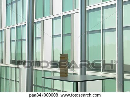 Stock Photo - Stack of books and office building facade. Fotosearch