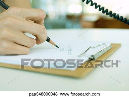 Person using phone, writing down phone number on clipboard, extreme close-up View Large Photo Image Stock Photo - Person using phone, writing down phone number on clipboard, extreme close-up. Fotosearch