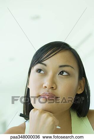 Woman resting head on hand, holding pen, looking away View Large Photo Image Stock Photograph - Woman resting head on hand, holding pen, looking away. Fotosearch