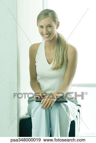 Woman sitting with file on knees View Large Photo Image Stock Photo - Woman sitting with file on knees. Fotosearch