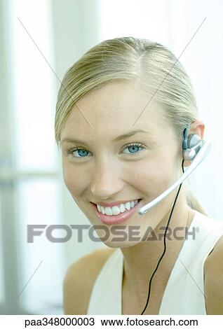 Stock Image - Woman wearing headset. Fotosearch