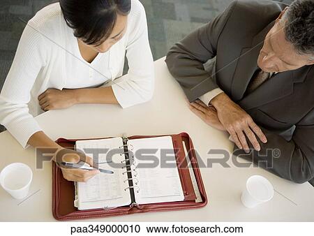 Executive and assistant looking at agenda together View Large Photo Image Stock Image - Executive and assistant looking at agenda together. Fotosearch