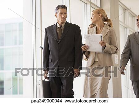 Group of business executives walking through corridor View Large Photo Image Picture - Group of business executives walking through corridor. Fotosearch