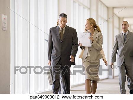 Group of business executives walking through corridor View Large Photo Image Stock Image - Group of business executives walking through corridor. Fotosearch