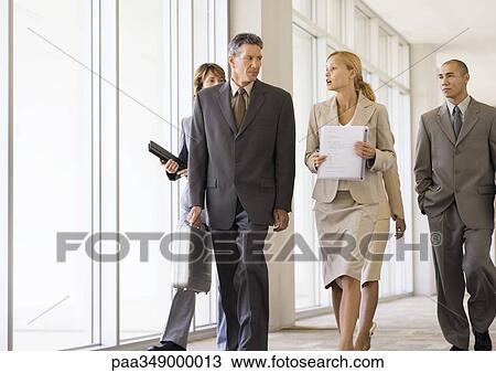 Group of business executives walking through corridor View Large Photo Image Stock Image - Group of business executives walking through corridor. Fotosearch