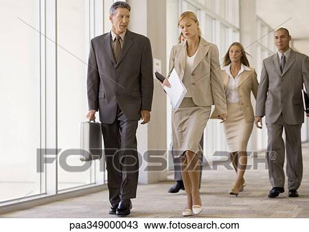 Group of business executives walking through corridor View Large Photo Image Stock Image - Group of business executives walking through corridor. Fotosearch