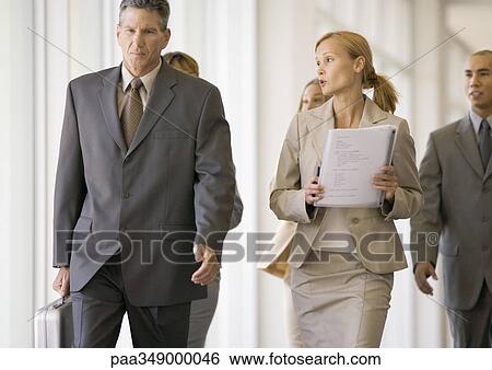 Group of business executives walking through corridor View Large Photo Image Stock Photograph - Group of business executives walking through corridor. Fotosearch