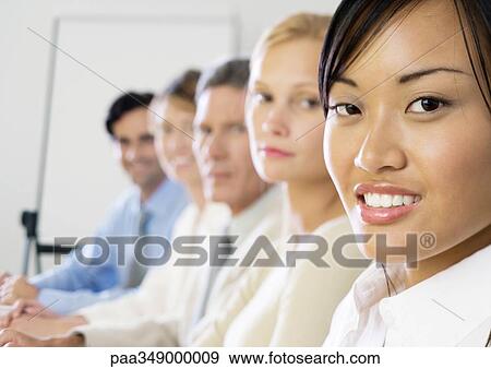 Group of exectives, sitting in a row, focus on foreground View Large Photo Image Stock Photo - Group of exectives, sitting in a row, focus on foreground. Fotosearch