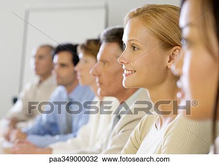 Stock Image - Group of executives in meeting, side view. Fotosearch