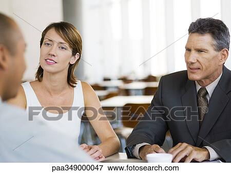 Stock Photo - Three business colleagues having conversation. Fotosearch