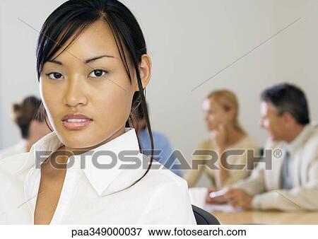 Young businesswoman, meeting in background View Large Photo Image Stock Photo - Young businesswoman, meeting in background. Fotosearch