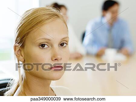 Young businesswoman sitting in meeting, looking at camera View Large Photo Image Stock Photo - Young businesswoman sitting in meeting, looking at camera. Fotosearch