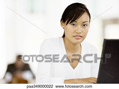 Young woman using laptop View Large Photo Image Stock Image - Young woman using laptop. Fotosearch