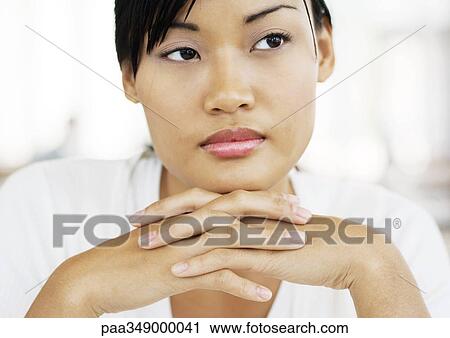Young woman with hands clasped under chin, looking away View Large Photo Image Stock Image - Young woman with hands clasped under chin, looking away. Fotosearch