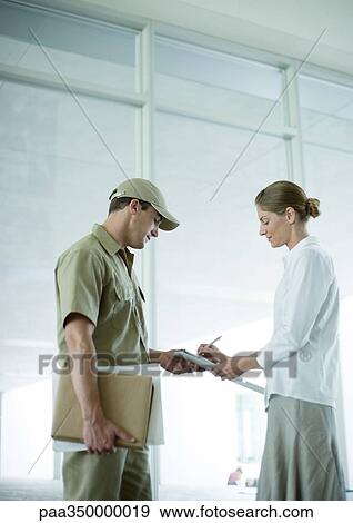 Receptionist signing for delivery View Large Photo Image Stock Photo - Receptionist signing for delivery. Fotosearch