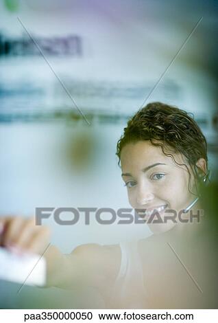 Woman wearing headset and holding out card View Large Photo Image Stock Image - Woman wearing headset and holding out card. Fotosearch
