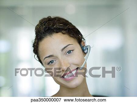 Stock Photo - Woman wearing headset and smiling. Fotosearch