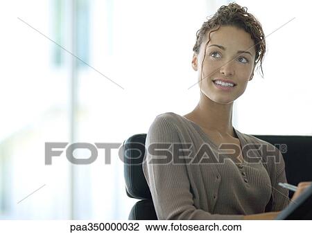 Woman writing and looking up View Large Photo Image Stock Image - Woman writing and looking up. Fotosearch