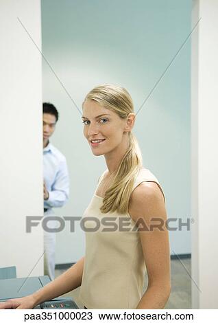 Female office worker standing next to copy machine View Large Photo Image Stock Image - Female office worker standing next to copy machine. Fotosearch