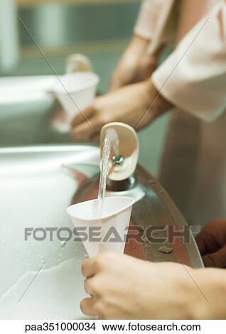 Filling cups at water fountain View Large Photo Image Picture - Filling cups at water fountain. Fotosearch