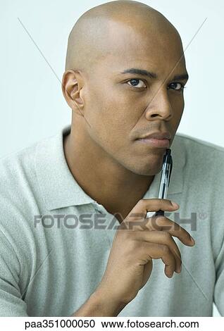 Man holdng pen to chin, portrait View Large Photo Image Stock Image - Man holdng pen to chin, portrait. Fotosearch