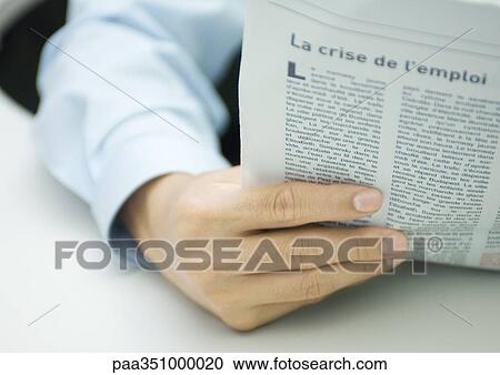 Stock Image - Man's hand holding newspaper. Fotosearch