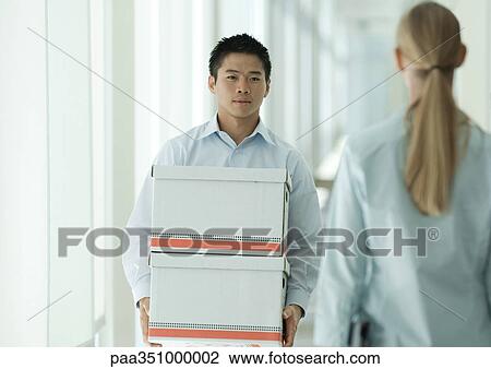 Office worker carrying boxes through corridor View Large Photo Image Stock Image - Office worker carrying boxes through corridor. Fotosearch