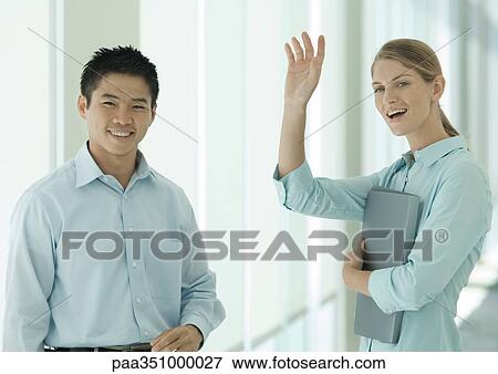 Office workers smiling and waving to camera View Large Photo Image Stock Photo - Office workers smiling and waving to camera. Fotosearch