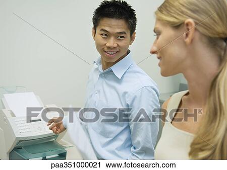 Two colleagues standing near fax machine View Large Photo Image Stock Image - Two colleagues standing near fax machine. Fotosearch