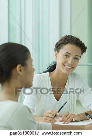 Stock Photo - Two women working together. Fotosearch