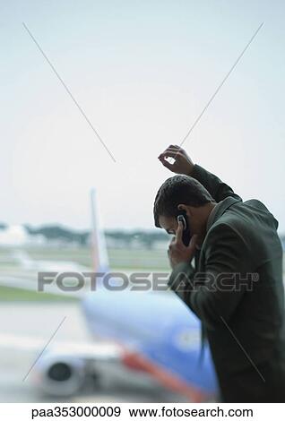 Man phoning, airplane in background View Large Photo Image Stock Photo - Man phoning, airplane in background. Fotosearch