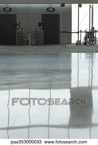 Reflection on airport floor, person in wheelchair waiting for assistance in background View Large Photo Image Stock Image - Reflection on airport floor, person in wheelchair waiting for assistance in background. Fotosearch