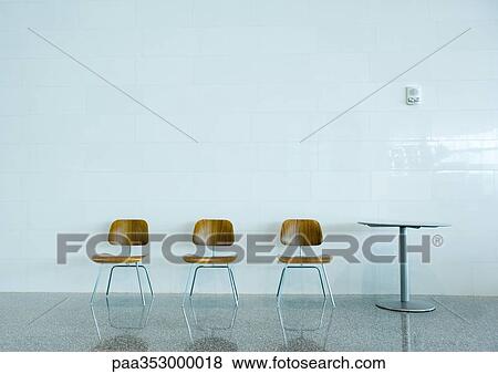 Three chairs in a row and a table View Large Photo Image Stock Photo - Three chairs in a row and a table. Fotosearch