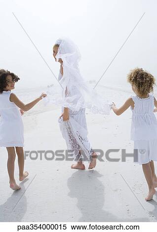 Bride and flower girls running on beach View Large Photo Image Stock Photography - Bride and flower girls running on beach. Fotosearch
