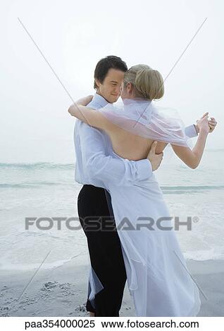 Stock Photography - Bride and groom dancing on beach. Fotosearch