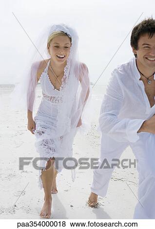 Bride and groom running on beach View Large Photo Image Stock Photo - Bride and groom running on beach. Fotosearch