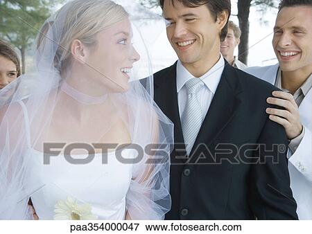 Stock Photo - Bride and groom surrounded by friends. Fotosearch