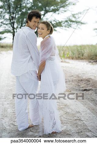 Bride and groom walking on sand View Large Photo Image Picture - Bride and groom walking on sand. Fotosearch