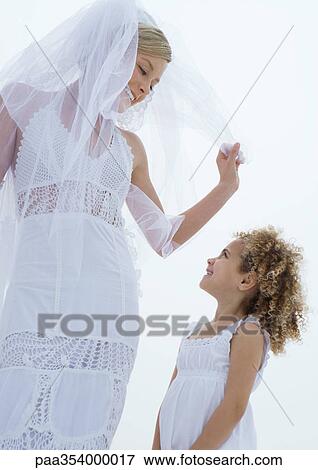 Bride looking down at flower girl View Large Photo Image Stock Photo - Bride looking down at flower girl. Fotosearch